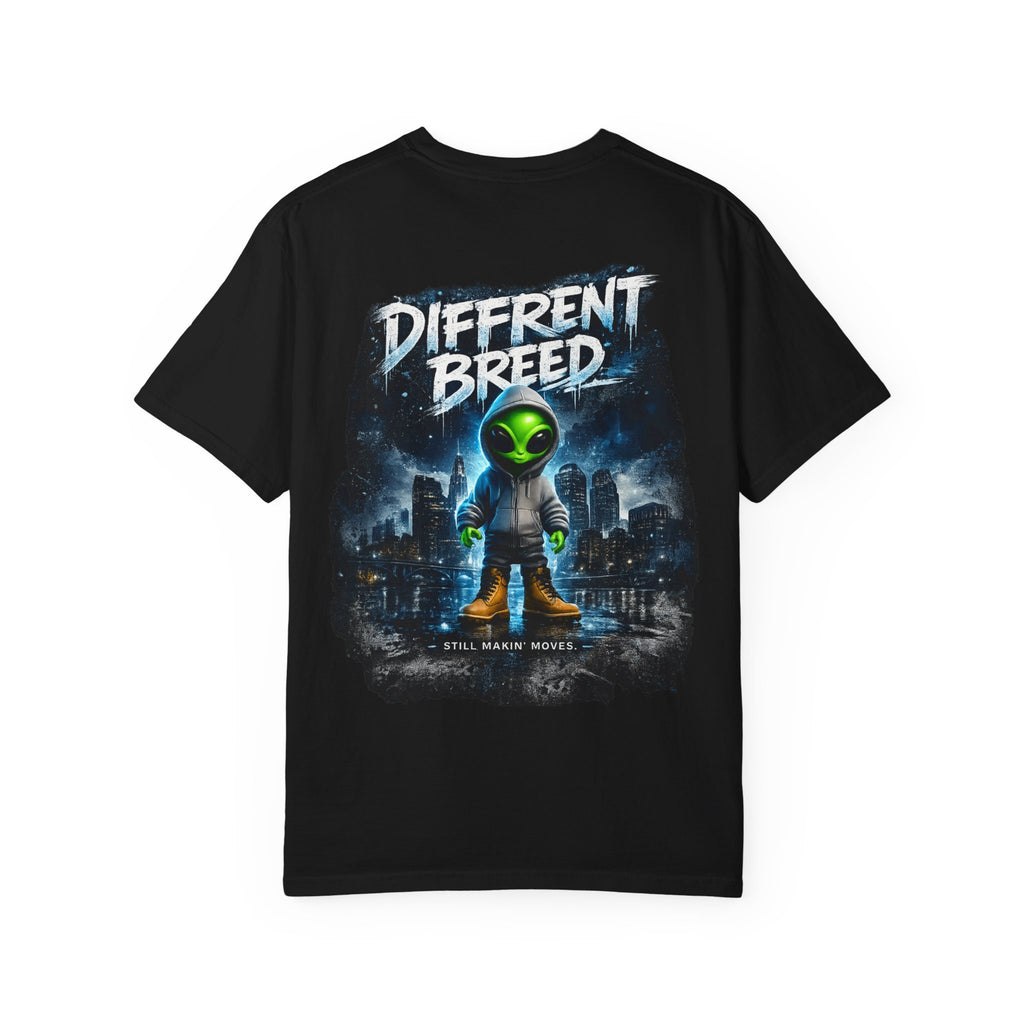 A black short-sleeve t-shirt with a large graphic print on the front. The graphic features a stylized green alien in a space suit standing in front of a dark city skyline under a dark blue sky, with the text 'DIFFRENT BREED' in a distressed white font at the top and 'STILL MAKING MOVIES' at the bottom.