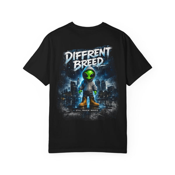 A black short-sleeve t-shirt with a large graphic print on the front. The graphic features a stylized green alien in a space suit standing in front of a dark city skyline under a dark blue sky, with the text 'DIFFRENT BREED' in a distressed white font at the top and 'STILL MAKING MOVIES' at the bottom.